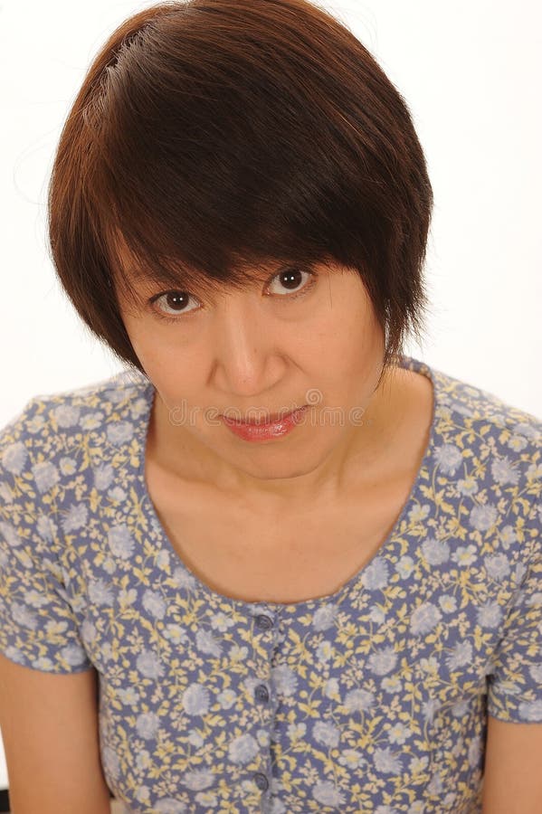 Head and shoulders studio shot of an Asian woman with a shy expression, isolated on a white background. Head and shoulders studio shot of an Asian woman with a shy expression, isolated on a white background.