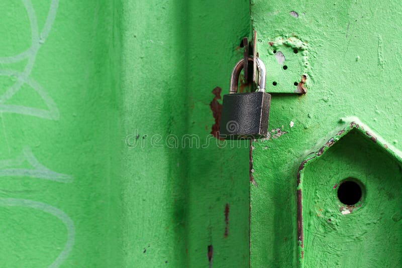 Затрапезная зеленая дверь закрытая padlock стоковое изображение Затрапезная зеленая дверь закрытая padlock стоковое изображение