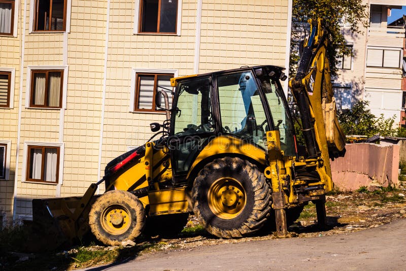 Затяжелитель Backhoe в переулке стоковое изображение Затяжелитель Backhoe в переулке стоковое изображение