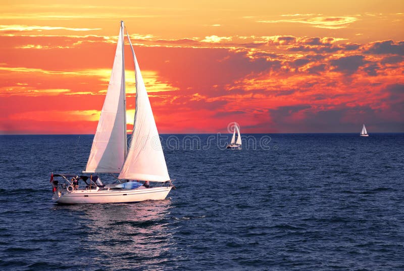 Sailboat sailing on a calm evening with dramatic sunset. Sailboat sailing on a calm evening with dramatic sunset