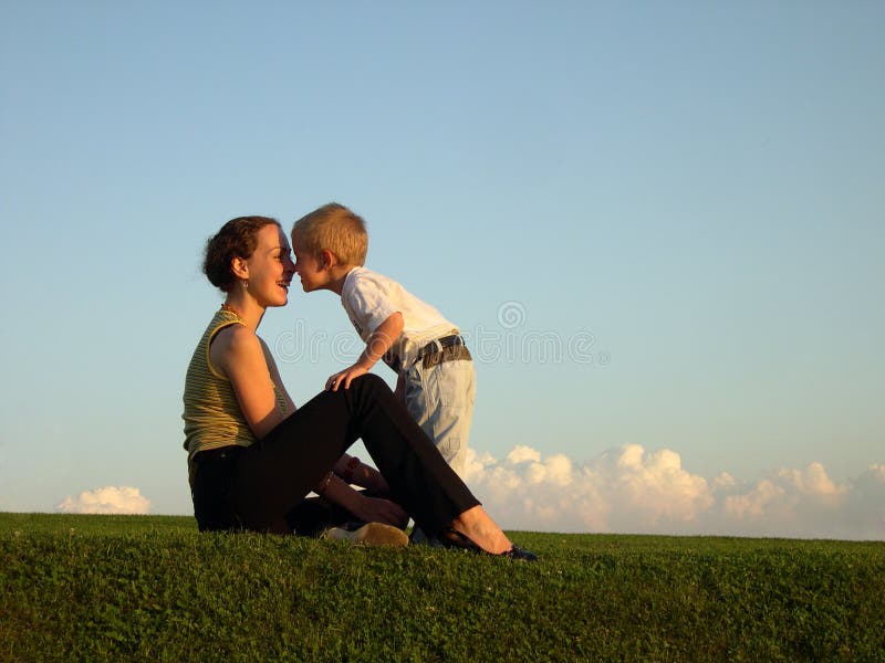 Mother with son on sundown kiss by nose, clouds on horizon. Mother with son on sundown kiss by nose, clouds on horizon