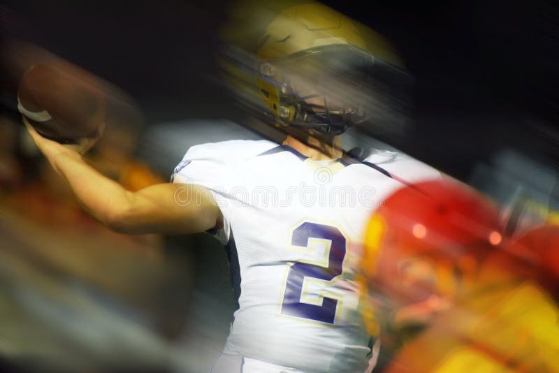 The quarterback in an American Football game makes a throw in a photo illustration. The quarterback in an American Football game makes a throw in a photo illustration