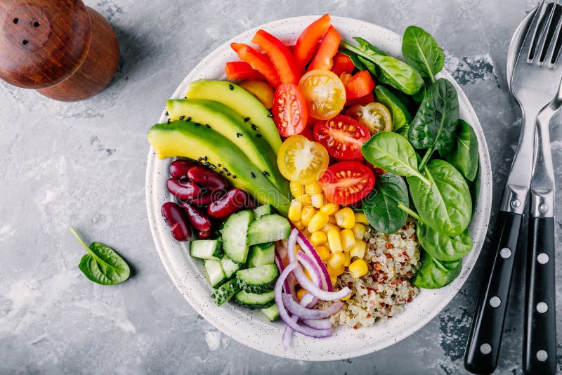 Здоровый шар Будды обеда vegan Авокадо, квиноа, томат, огурец, красные фасоли, шпинат, красный лук и красный салат овощей паприки стоковое изображение Здоровый шар Будды обеда vegan Авокадо, квиноа, томат, огурец, красные фасоли, шпинат, красный лук и красный салат овощей паприки стоковое изображение