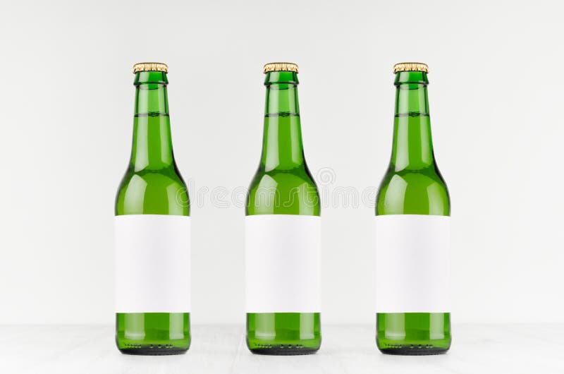 3 зеленых пивной бутылки 330ml longneck с пустым белым ярлыком на белой деревянной доске, глумятся вверх стоковое фото 3 зеленых пивной бутылки 330ml longneck с пустым белым ярлыком на белой деревянной доске, глумятся вверх стоковое фото