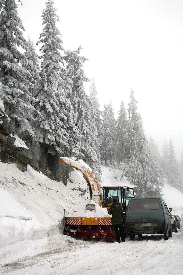 Snowplow in action on rural snow covered road. Winter in Balkans Mountain - Kosovo. Snowplow in action on rural snow covered road. Winter in Balkans Mountain - Kosovo