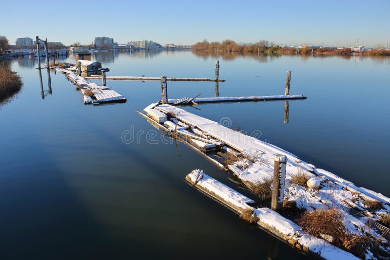 A glassy smooth surface of the Fraser River flowing through Richmond, BC, Canada during winter. A glassy smooth surface of the Fraser River flowing through Richmond, BC, Canada during winter.