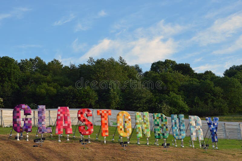 Знак фестиваля Glastonbury с голубым небом и белыми облаками позади стоковая фотография Знак фестиваля Glastonbury с голубым небом и белыми облаками позади стоковая фотография