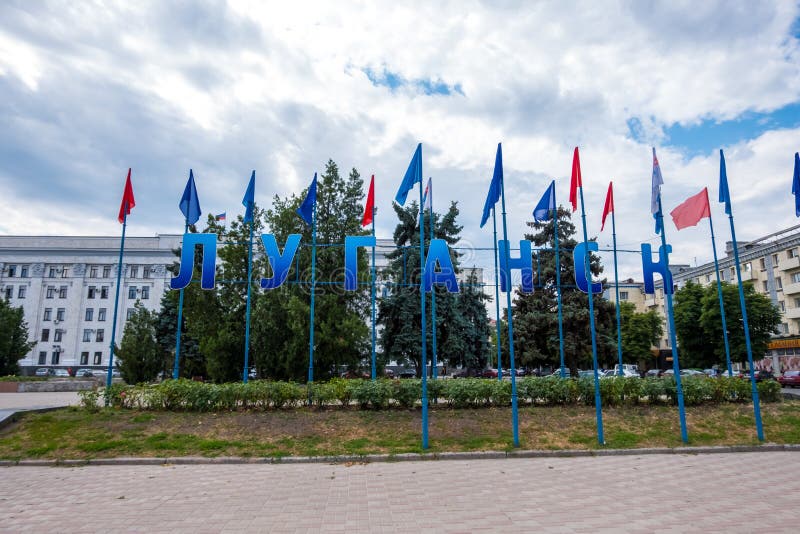 Луганск, Украина - Jule 10, 2019: Знак я люблю Луганск на центральной площади Teatralna около памятника Ленин, взгляда улицы в Луганск
