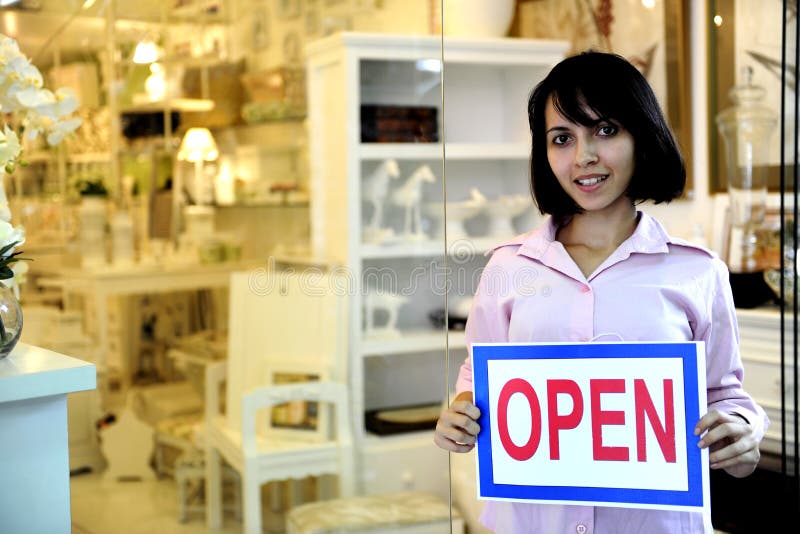 Portait of small business owner: woman holding an open sign infront of store. Portait of small business owner: woman holding an open sign infront of store