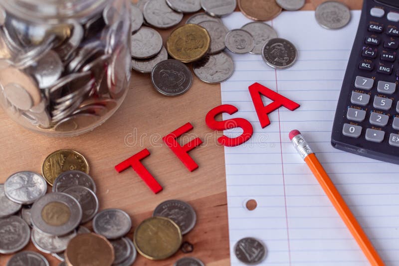 Знаки сберегательного счета налога „TFSA „свободные с монетками на заднем плане стоковые фотографии rf Знаки сберегательного счета налога „TFSA „свободные с монетками на заднем плане стоковые фотографии rf