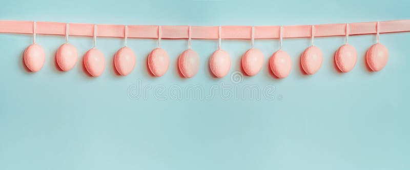 Знамя или шаблон пасхи Красивый пастельный пинк eggs смертная казнь через повешение на ленте на на голубой предпосылке бирюзы стоковое фото rf