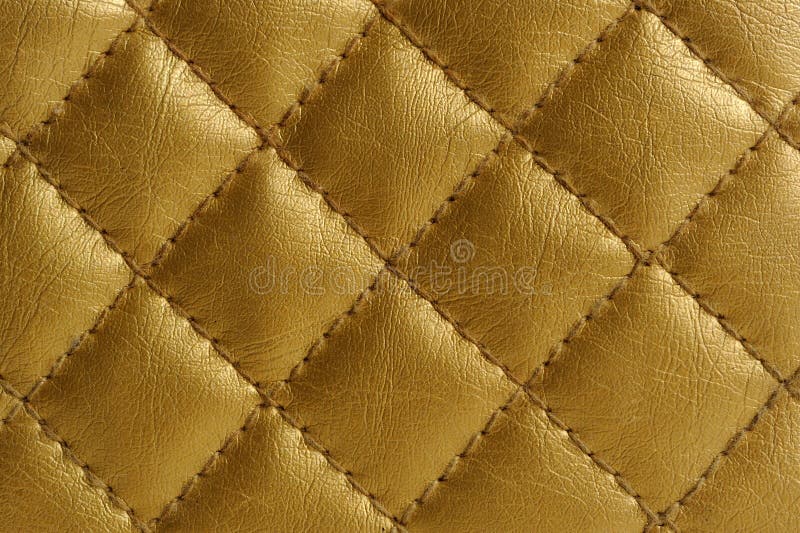 A close-up of golden quilted leather as a background. A close-up of golden quilted leather as a background