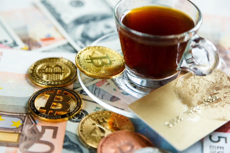 Золотая монетка валюты Bitcoin секретная на долларе, предпосылке банкнот евро и кредитной карточке около чашки кофе облечения стоковые изображения Золотая монетка валюты Bitcoin секретная на долларе, предпосылке банкнот евро и кредитной карточке около чашки кофе облечения стоковые изображения