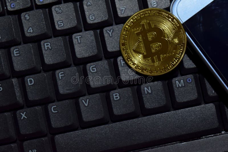 Золото и смартфон Bitcoin на предпосылке ноутбука клавиатуры Концепция торговлей и делом стоковые изображения rf Золото и смартфон Bitcoin на предпосылке ноутбука клавиатуры Концепция торговлей и делом стоковые изображения rf