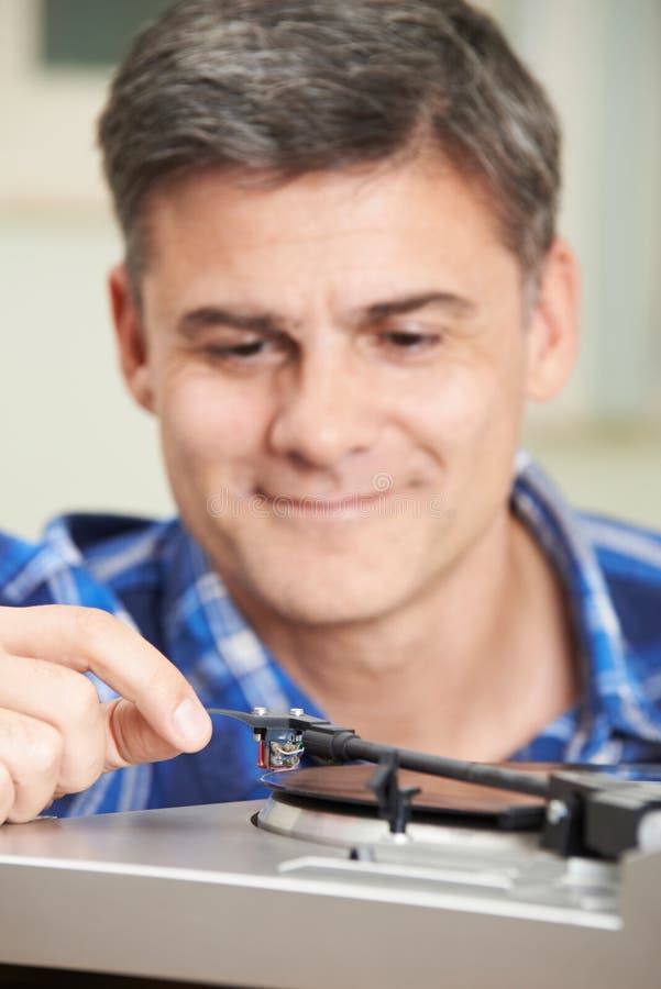 Man Putting Vinyl Record On Player. Man Putting Vinyl Record On Player