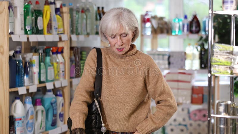 Зрелая женщина выбирает гладильную доску в магазине с бытовой химией. видеоматериал
