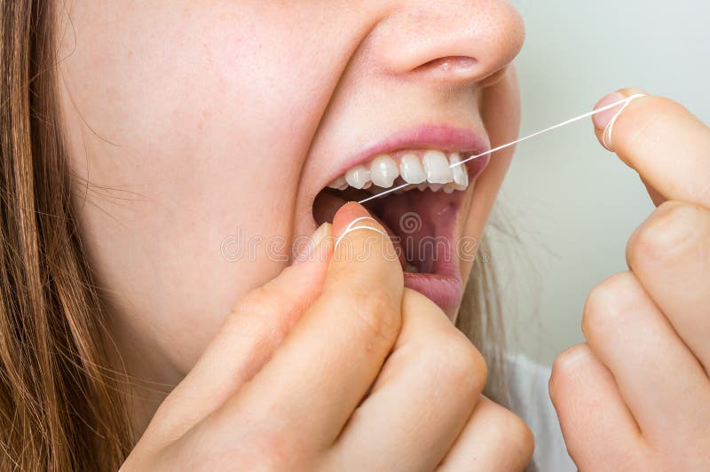 Woman flossing teeth with dental floss - oral and teeth hygiene. Woman flossing teeth with dental floss - oral and teeth hygiene