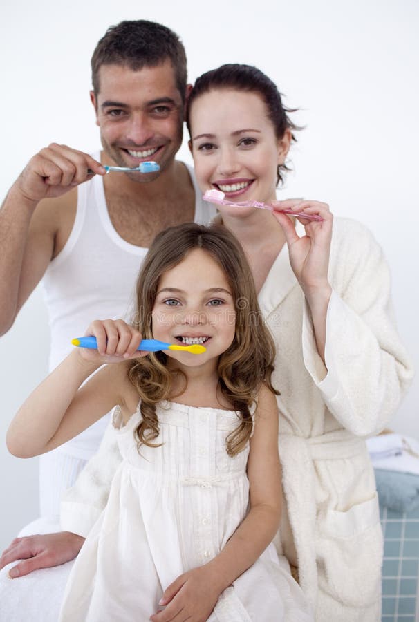Happy family cleaning their teeth together in bathroom. Happy family cleaning their teeth together in bathroom