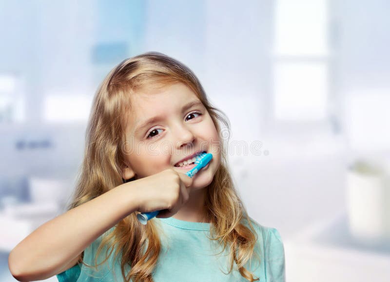 Child girl closeup cleaning teeth in bathroom. Caucasian happy smiling kid brush teeth. Child girl closeup cleaning teeth in bathroom. Caucasian happy smiling kid brush teeth.