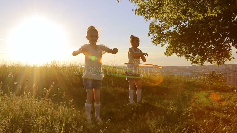 Игра 2 девушек детей с hula-обручем