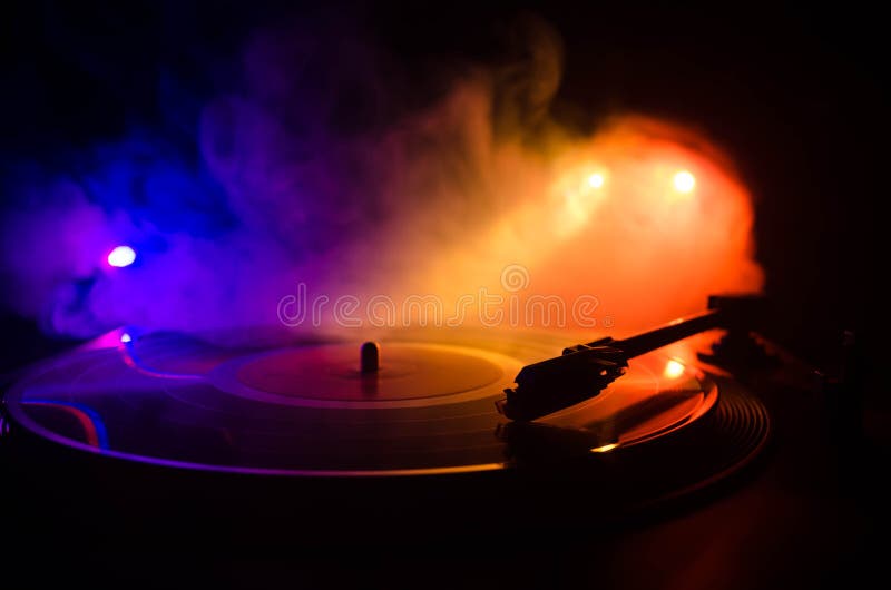 Turntable vinyl record player. Retro audio equipment for disc jockey. Sound technology for DJ to mix & play music. Vinyl record being played against burning fire background with smoke. Turntable vinyl record player. Retro audio equipment for disc jockey. Sound technology for DJ to mix & play music. Vinyl record being played against burning fire background with smoke