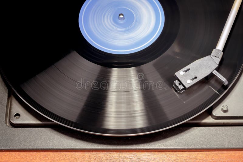 Detail of vintage record player with spinning vinyl. Motion blur image. Detail of vintage record player with spinning vinyl. Motion blur image.