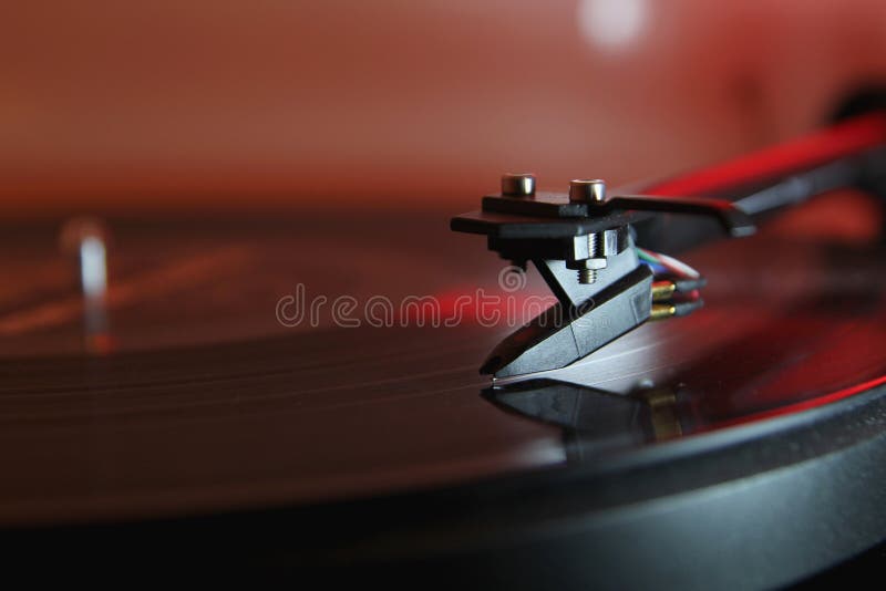 Modern high quality turntable record player playing a vinyl analogue music LP with red back light. Modern high quality turntable record player playing a vinyl analogue music LP with red back light