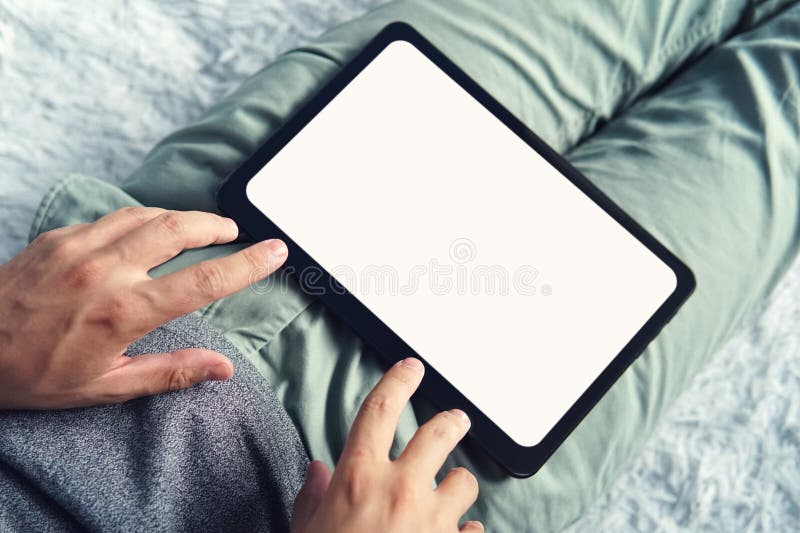Идущая сверху вниз съемка длинного сидя человека с цифровым планшетом на его ногах Человек на началах софы работая на пустом стоковые фото Идущая сверху вниз съемка длинного сидя человека с цифровым планшетом на его ногах Человек на началах софы работая на пустом стоковые фото