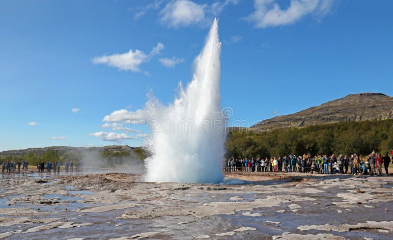 Извержение Strokkur гейзера Исландии на красивый солнечный летний день, с непознаваемыми туристами стоковые изображения rf