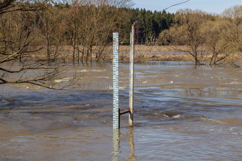 Измеряющ уровень воды во время прилива на реке весной стоковые фотографии rf Измеряющ уровень воды во время прилива на реке весной стоковые фотографии rf