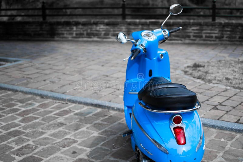 Изображение Desatured голубых классических скутера или vespa Пежо Django припарковало в улице