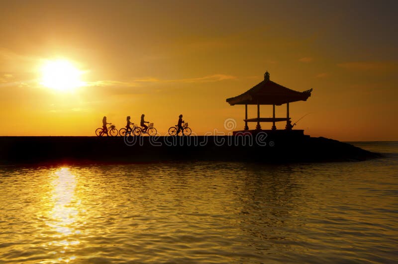 Image of cyclists riding on a concrete barrier in bali indonesia Sanur beach at sunrise. This is a great place to visit when you are in Bali . Image of cyclists riding on a concrete barrier in bali indonesia Sanur beach at sunrise. This is a great place to visit when you are in Bali ..