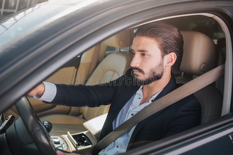 Изображение славного и уверенного бизнесмена сидя в роскошном автомобиле Он смотрит прямодушным Представления человека Он имеет р стоковое изображение Изображение славного и уверенного бизнесмена сидя в роскошном автомобиле Он смотрит прямодушным Представления человека Он имеет р стоковое изображение