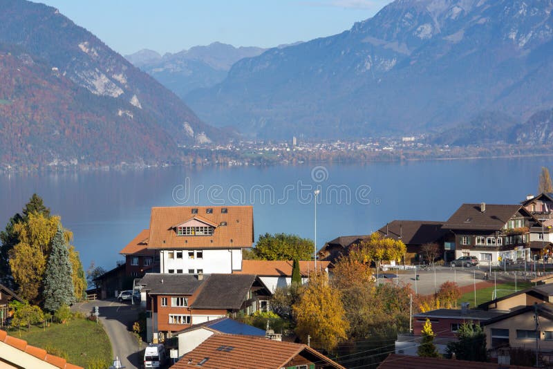 Изумительный вид на озеро Thun и типичная деревня Швейцарии около городка Интерлакена стоковое изображение Изумительный вид на озеро Thun и типичная деревня Швейцарии около городка Интерлакена стоковое изображение