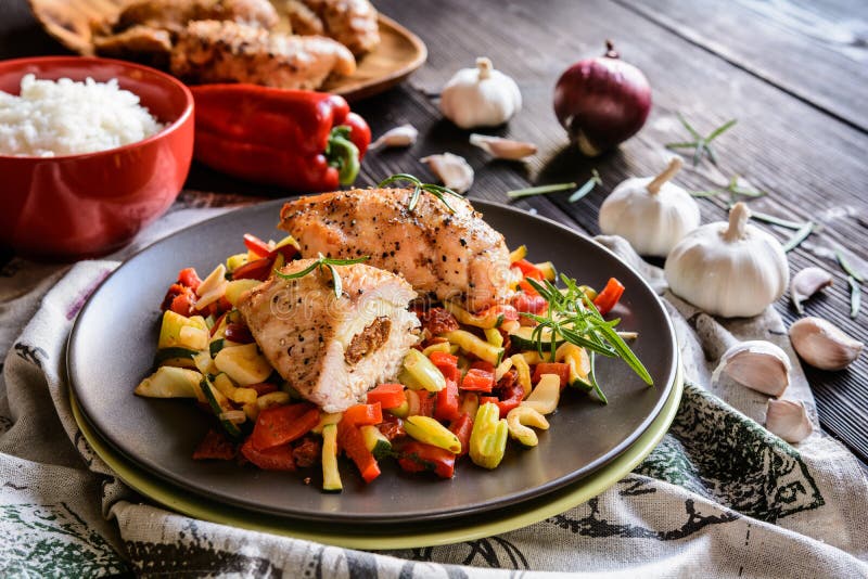 Испеченная куриная грудка заполненная с сыром, томатом и базиликом с рисом и испаренным vegetable салатом стоковое фото rf Испеченная куриная грудка заполненная с сыром, томатом и базиликом с рисом и испаренным vegetable салатом стоковое фото rf
