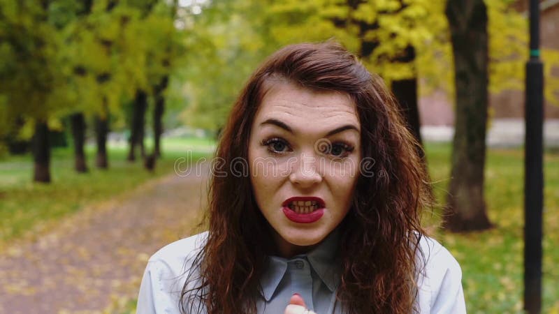 Истеричная сердитая молодая женщина redhead в парке сток-видео