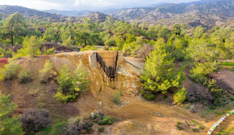 Historical copper mining area since antiquity in Kalavasos, Cyprus. Ore bin and mine tailings from 1950s, and hills of Roman slug behind them. Historical copper mining area since antiquity in Kalavasos, Cyprus. Ore bin and mine tailings from 1950s, and hills of Roman slug behind them