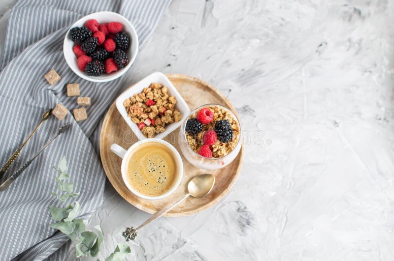 Йогурт здоровой чашки кофе завтрака греческий с домодельным Granola, ягоды, поленики и ежевики работают ноутбук стоковая фотография Йогурт здоровой чашки кофе завтрака греческий с домодельным Granola, ягоды, поленики и ежевики работают ноутбук стоковая фотография