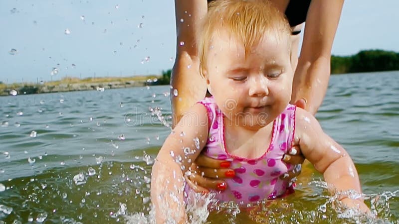 Кавказская женская прыжок первого ребенка на море в воду акции видеоматериалы
