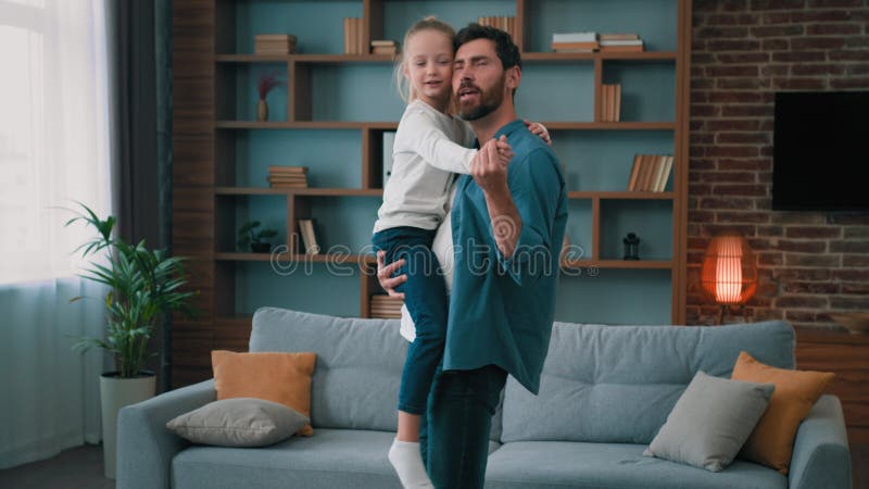 кавказский отец, заботящийся о родителях, танцует медленно с маленькой дочкой миленькой девочкой семейная вечеринка в гостиной видеоматериал - Видео насчитывающей бомб, дети: 260006700