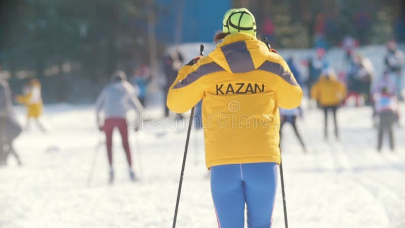 КАЗАНЬ, РОССИЯ - МАРТ 2018: Назад девушки участника на следе лыжи видеоматериал