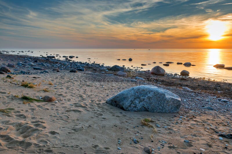 Каменистый пляж Балтийского моря, заход солнца стоковое изображение Каменистый пляж Балтийского моря, заход солнца стоковое изображение