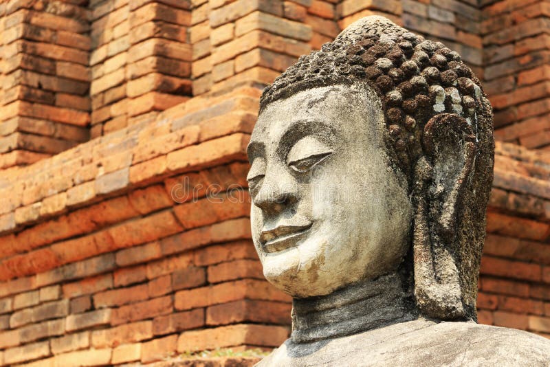 Каменная предпосылка красного кирпича статуи Будды