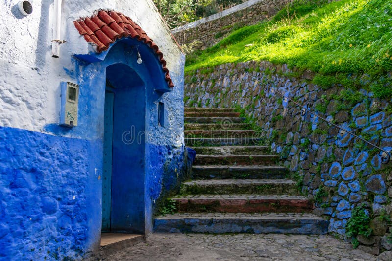 Каменные лестницы вверх по холму рядом с голубым коттеджем в Chefchaouen Марокко стоковые фото Каменные лестницы вверх по холму рядом с голубым коттеджем в Chefchaouen Марокко стоковые фото