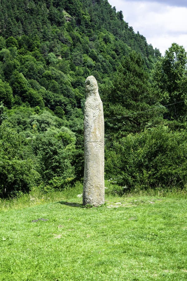 Каменный идол восьмого века на предпосылке зеленого леса, Arkhyz, Karachay-Cherkessia, России стоковые изображения rf Каменный идол восьмого века на предпосылке зеленого леса, Arkhyz, Karachay-Cherkessia, России стоковые изображения rf