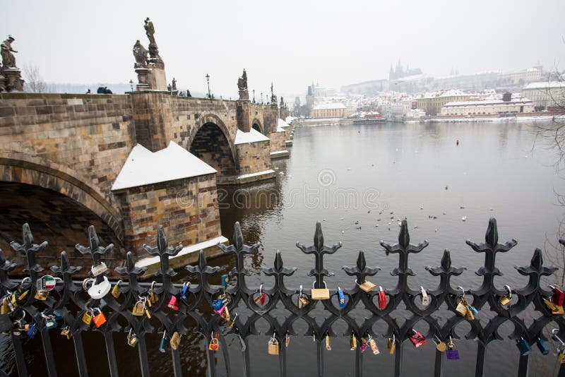 Карлов мост и замок Праги в зиме с Padlocks в переднем плане стоковое фото