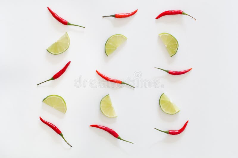 Картина накаленных докрасна перцев chili и отрезанных известок на белой предпосылке стоковая фотография rf Картина накаленных докрасна перцев chili и отрезанных известок на белой предпосылке стоковая фотография rf