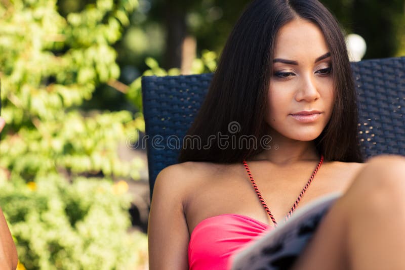 Кассета чтения женщины на deckchair стоковая фотография rf Кассета чтения женщины на deckchair стоковая фотография rf