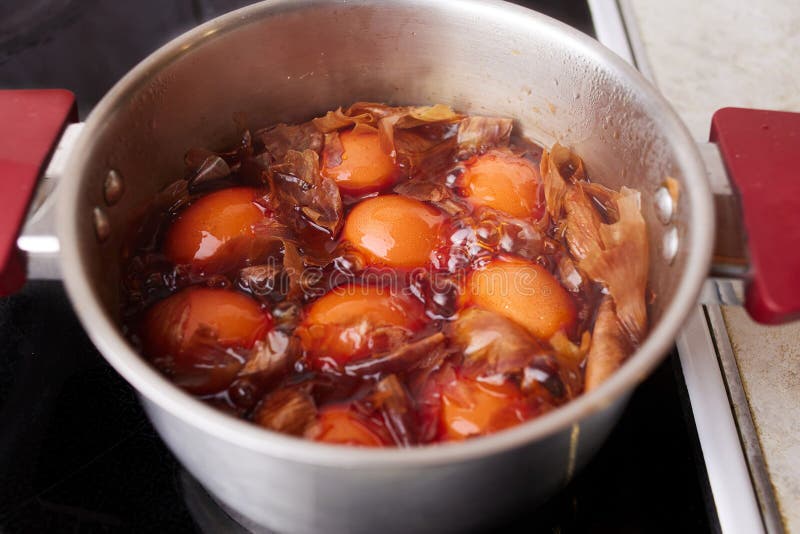 Кастрюля с вареными куриными яйцами с луковой шелухой. Окрашивание яиц в натуральные красители для праздника Пасхи стоковая фотография rf