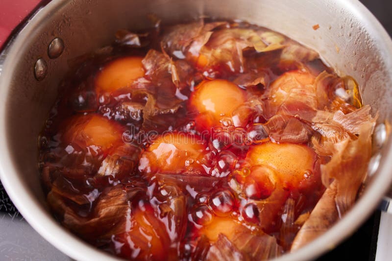 Кастрюля с вареными куриными яйцами с луковой шелухой. Окрашивание яиц в натуральные красители для праздника Пасхи стоковые изображения rf